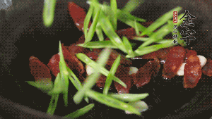 先后下香腸片、四季豆絲均勻翻炒，加適量清水燜煮一下。