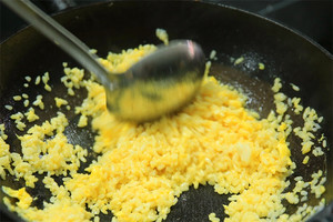 大火加熱炒鍋，再入油，燒到四至五成熱時(shí)倒入雞蛋液，在未凝結(jié)之前，加米飯煸炒，不停翻炒并用鍋鏟將成塊的米飯碾開(kāi)、撥散。