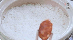 煮開后轉小火，當米飯出現(xiàn)小孔時，鋪上金字麻辣香腸。