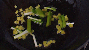 鍋中熱油，依次下姜粒、蔥段、蘆筍炒香。
