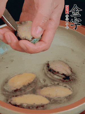 鮑魚加鹽、清水浸泡，用勺子挖出鮑魚肉。