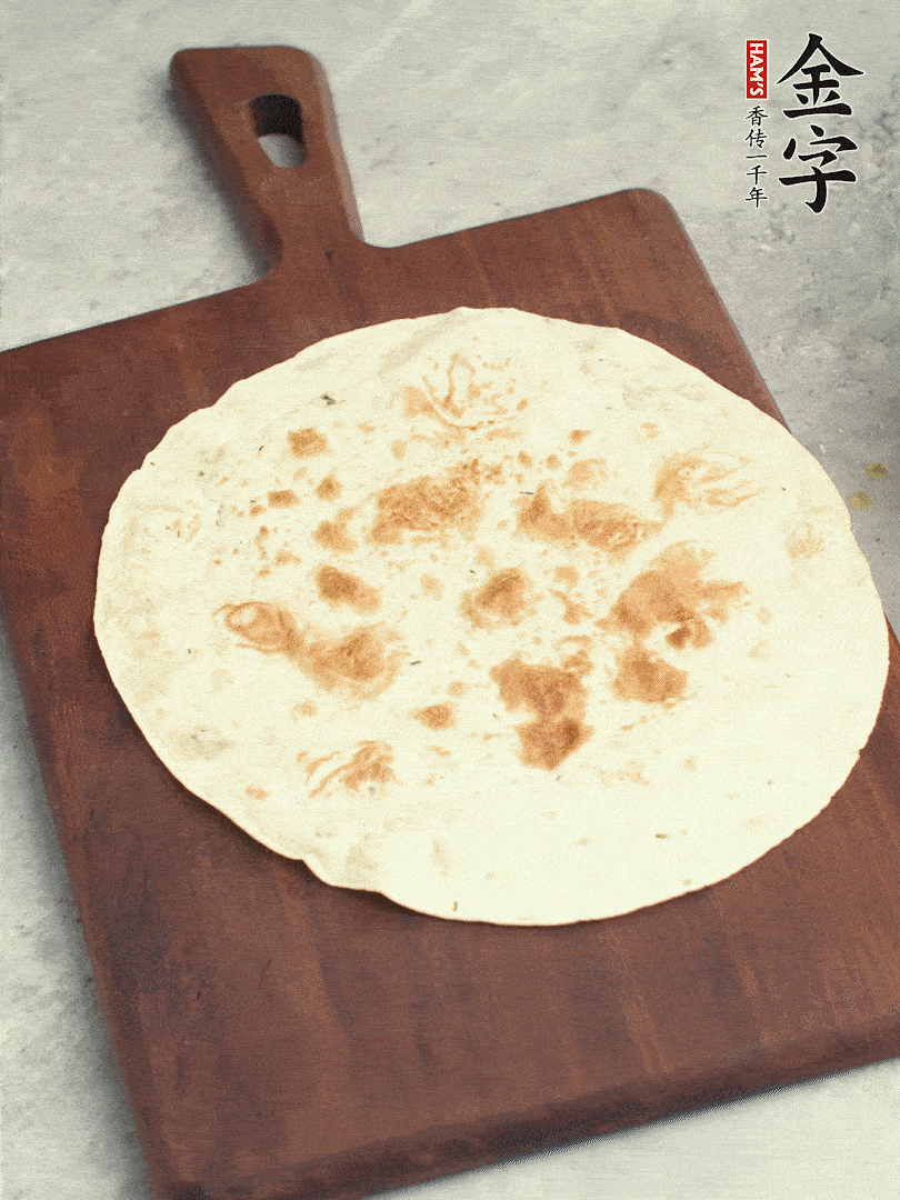 食材依次鋪在卷餅皮上，卷起來(lái)。