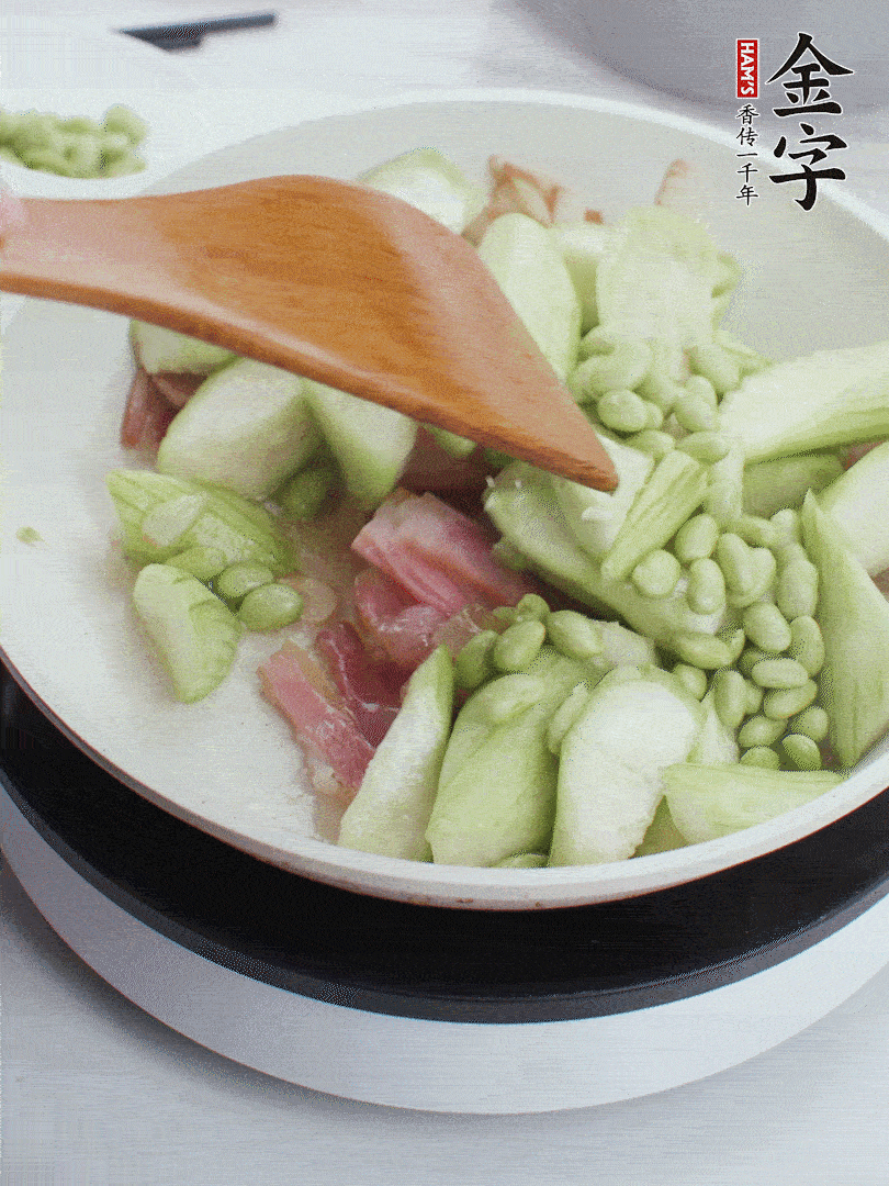 依次下絲瓜、青豆翻炒，炒至絲瓜打蔫縮小。