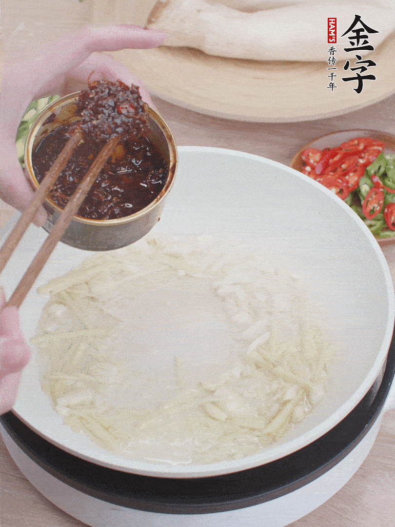 起鍋熱油，姜蒜、金字火腿干貝醬煸香。