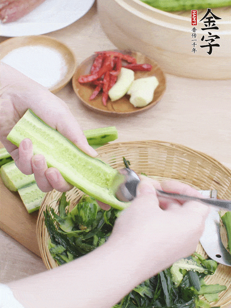 黃瓜削皮，對(duì)半切開(kāi)，勺子挖去內(nèi)瓤，斜刀切片。青蒜斜刀切段。