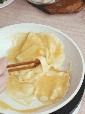 油6成熱時(shí)，下雞蛋液，邊緣凝固時(shí)翻拌成塊狀。