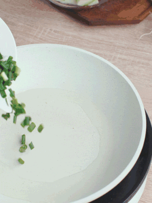 熱油下臘肉、蔥花煸炒，再下西葫蘆。