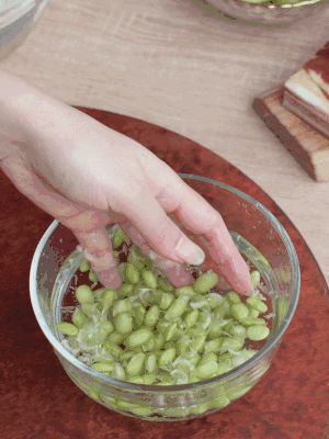 青豆剝殼，搓去外衣。