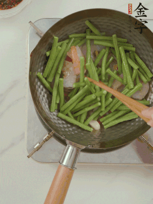 下掰好的缸豆段翻炒，略燜煮。
