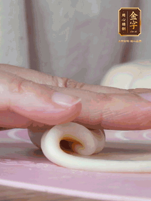 做面劑 油皮按扁，中間包入一個油酥，邊緣收緊捏死。包好的面劑按扁，用搟面杖搟壓成橢圓形。從底部向上卷成筒狀，用保鮮膜蓋好松弛15分鐘，再把筒狀縱向搟壓成長條狀。再卷一次，松弛20分鐘