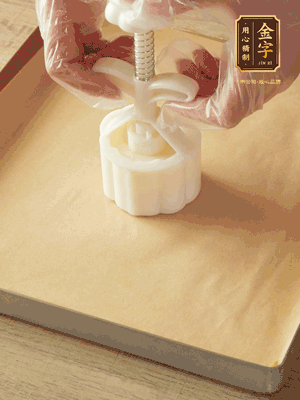 取一個(gè)面團(tuán)，捏扁，中間厚，四周薄。虎口往上推，直到收口，把餅胚放入模具里，壓2-3下