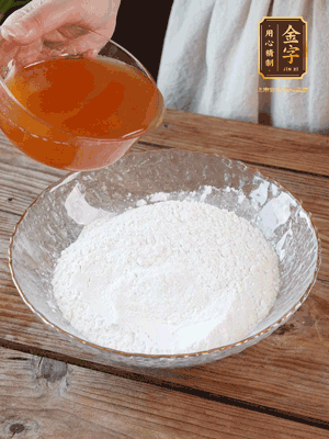 轉化糖漿、枧水、花生油攪拌均勻，加入面粉混合，醒發(fā)2小時。捏成23g一個的小球