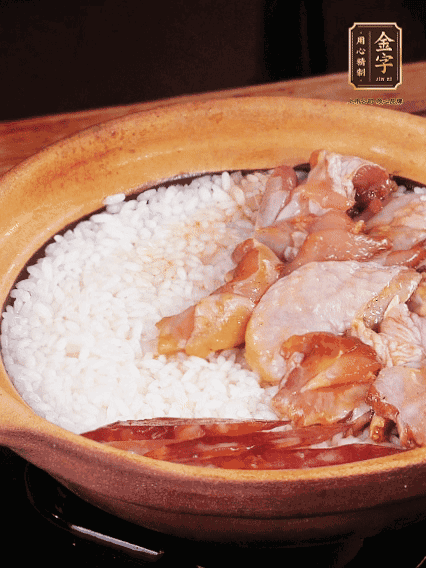 煮到椰子水微微收干轉(zhuǎn)小火，快速均勻鋪上雞肉、金字香腸